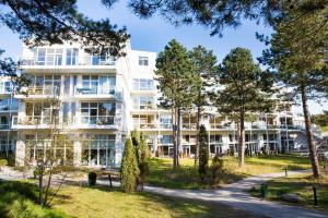 ein Mehrfamilienhaus mit Bäumen davor in der Unterkunft Strandhotel Fischland in Dierhagen
