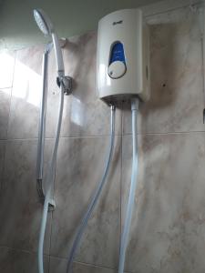 a shower in a bathroom with a blow dryer at Tyvabro Guesthouse in Mahébourg
