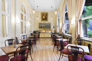 a restaurant with tables and chairs in a room with windows at Ersta Hotell & Konferens in Stockholm