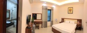 1 dormitorio con 1 cama y baño con lavamanos en Bình Minh Riverside Hotel, en Thái Bình