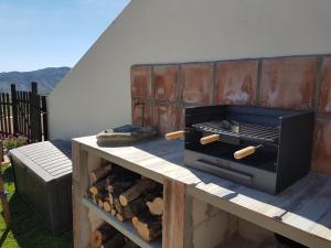 - un barbecue sur une table avec des bûches sur une terrasse dans l'établissement Casita Las Melosillas, à Casabermeja