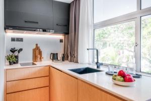 a kitchen with a sink and a bowl of fruit on the counter at Habyt Cantonment - formerly Hmlet Cantonment in Singapore