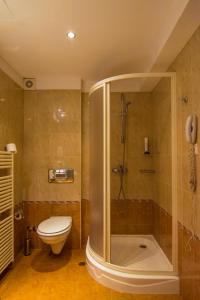 a bathroom with a shower and a toilet and a phone at Hotel Forum - Free Parking for cars in Sofia +27 photos