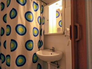 a bathroom with a sink and a shower curtain at Delfini Hotel in Piraeus