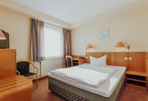 una camera d'albergo con un grande letto e una scrivania di Hotel Klute a Osnabrück
