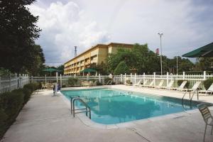 a large swimming pool with chairs and a building at Wingate by Wyndham Brunswick GA I-95 in Brunswick