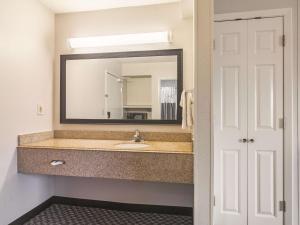 a bathroom with a sink and a mirror at Wingate by Wyndham Brunswick GA I-95 in Brunswick +25 photos
