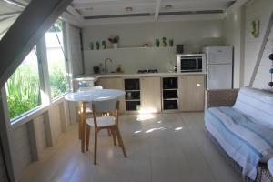 una piccola cucina con tavolo e un letto in una camera di EFFET MER a Capesterre