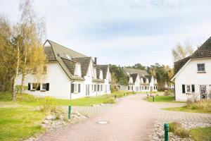 a cobblestone street in a village with white houses at Ferienwohnungen Fischland in Dierhagen