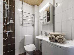 a white bathroom with a toilet and a sink at Citykoti Downtown Studios in Helsinki