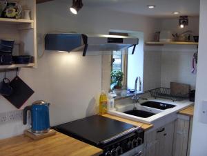 a small kitchen with a sink and a stove at Manor Holding Byre in Bewdley