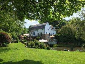 uma casa num rio com um jardim relvado em Castle Mill Bed and Breakfast em Dorking