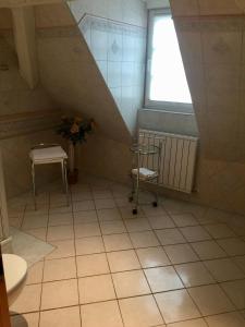La salle de bains est pourvue d'un escalier, d'une fenêtre et de carrelage. dans l'établissement Hostaria del Castello, à Marbourg