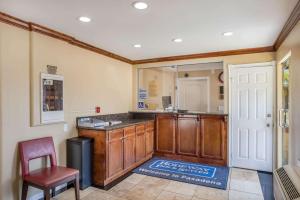 a bathroom with a counter and a sink and a chair at Rodeway Inn & Suites Pasadena in Pasadena