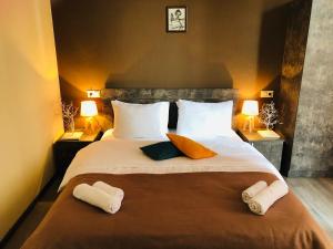 a bedroom with a large bed with two towels on it at Hotel Nabadi in Tbilisi City
