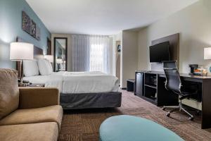 a hotel room with a bed and a desk at Sleep Inn & Suites near Westchase in Houston