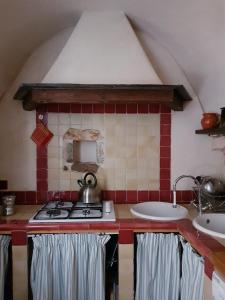 a kitchen with a stove and two sinks at Ca' de Pria in Borgio Verezzi