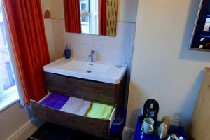 a bathroom with a sink and a mirror at Abinger Guest House in Leicester