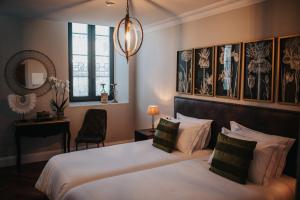 a hotel room with two beds and a mirror at 1930 Boutique Hotel in Arz&uacute;a