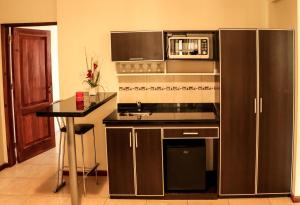 a kitchen with a stainless steel refrigerator and a microwave at Hotel Jardin De Iguazu in Puerto Iguazú +50 photos