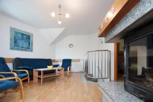 a living room with a fireplace and blue chairs at Apartamenty Solar in Wisła
