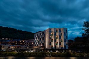 a building with cars parked in a parking lot at Quality Hotel Sogndal in Sogndal