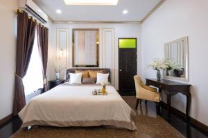 a bedroom with a bed and a desk and a desk at Lanna Kamin Pool Villa Airport in Chiang Mai