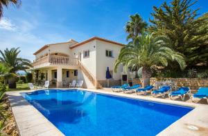 a villa with a swimming pool and palm trees at El Hayuco 10 in Jávea