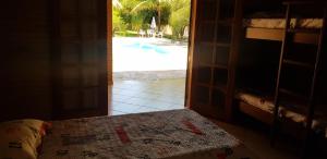 an open door to a bedroom with a view of a pool at Chacara Recanto dos Passaros 01 in Olímpia +35 photos