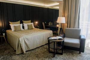 a hotel room with a bed and a chair at Spa Hotel Calista in Starozagorski Bani
