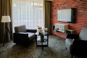 ein Wohnzimmer mit 2 Stühlen und einem TV in der Unterkunft Spa Hotel Calista in Starozagorski Bani