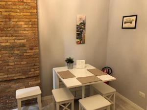 een tafel en stoelen in een kamer met een bakstenen muur bij LA CASA STELLA in Napels