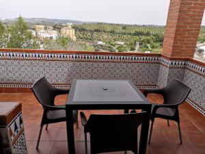 una mesa y sillas en un balcón con vistas en Casa Rural Guzman, en Setenil