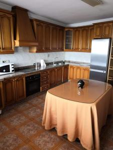 a kitchen with a table and a refrigerator at Casa Rural Guzman in Setenil