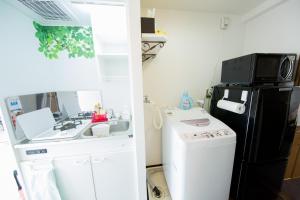 a small kitchen with a sink and a black refrigerator at Cozyhouse 310 free wifi a rented electric bicycle in Kyoto