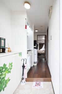 un corridoio che conduce a una cucina con pareti bianche di Cozyhouse 310 free wifi a rented electric bicycle a Kyoto