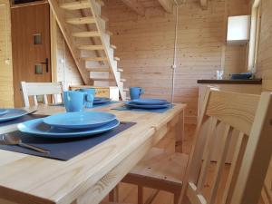 a wooden table with blue plates on top of it at Bungalow with a sunny terrace in Międzyzdroje