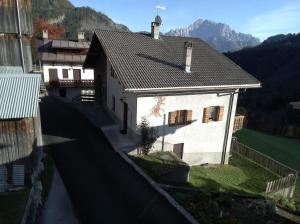 eine Luftansicht eines weißen Hauses mit einem Dach in der Unterkunft Al Becalen in Livinallongo del Col di Lana