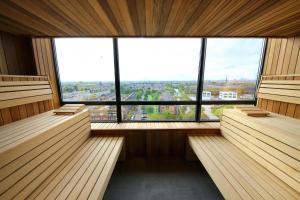 un sauna vide avec des bancs et une grande fenêtre dans l'établissement Van der Valk Hotel Den Haag, à Nootdorp