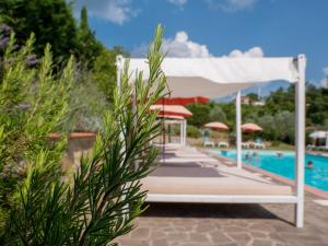 um dossel branco sobre uma piscina num resort em Hotel Villa San Giorgio em Poggibonsi