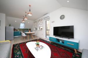 a living room with a large television and a table at Apartment STARI LISAC in Sarajevo