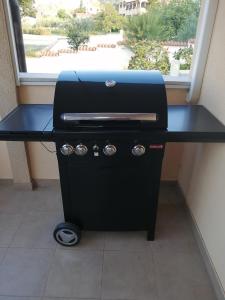 a grill sitting on a table next to a window at Terra Rossa in Loborika