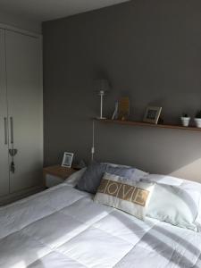 - une chambre avec un grand lit blanc et une étagère dans l'établissement Edificio Jardines del Country Piso 19, à Punta del Este 20 autres photos