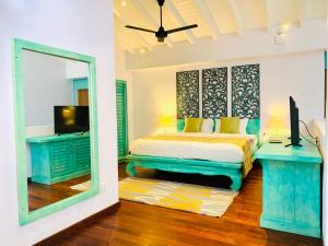 a bedroom with a bed and a tv and a mirror at Thaproban Pavilion Resort and Spa in Unawatuna