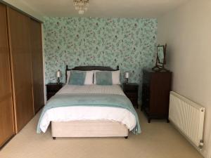 グレート・アイトンにある14 Easby Laneの花柄の壁紙を用いたベッドルーム1室(大型ベッド1台付)