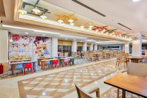 a dining room with tables and chairs in a cafeteria at Crystal Club World of Colours in Belek