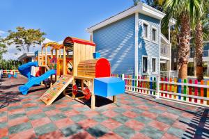 a playground with a colorful play set in front of a house at Crystal Club World of Colours in Belek