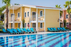 a villa with a swimming pool and blue lounge chairs at Crystal Club World of Colours in Belek