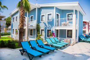 a group of blue lounge chairs in front of a house at Crystal Club World of Colours in Belek
