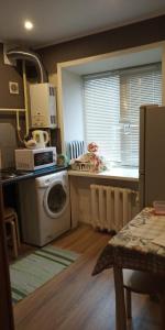 オレンブルクにあるApartment on prospekt Pobedyのキッチン(洗濯機、電子レンジ付)